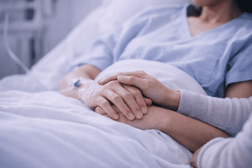 Paciente internado em leito hospitalar com acesso venoso recebendo suporte de acompanhante — navegação do paciente internado para reduzir tempo de permanência e melhorar a experiência assistencial.