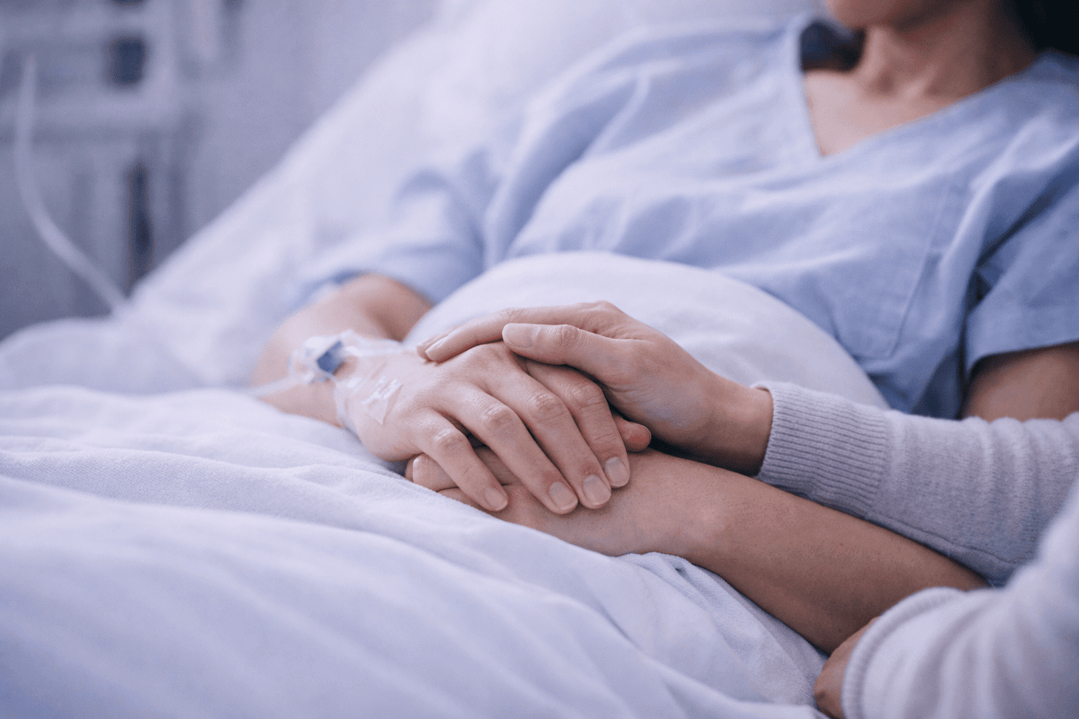 Paciente internado em leito hospitalar com acesso venoso recebendo suporte de acompanhante — navegação do paciente internado para reduzir tempo de permanência e melhorar a experiência assistencial.